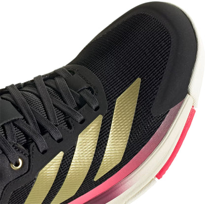 Close-up of the adidas Crazyquick Boost Men's Padel Shoes in Core Black/Gold Metallic/Solar Turbo, featuring black uppers with gold stripes, black laces, and a beige-pink sole for breathability and energy return.